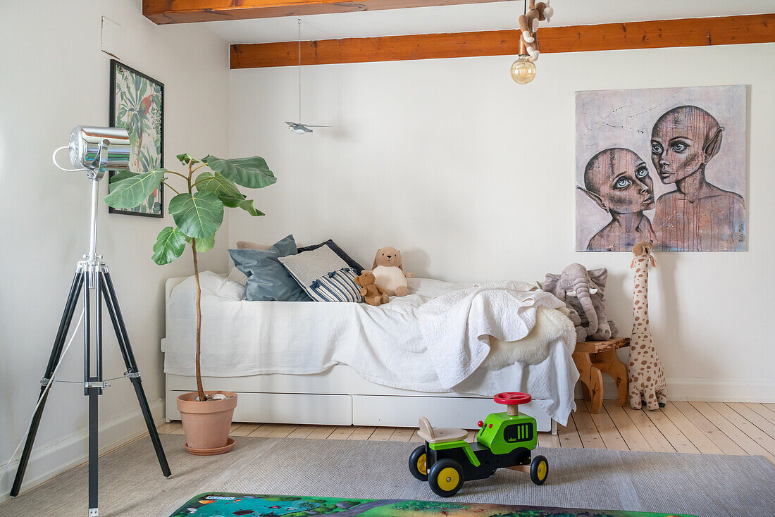 Kinderzimmer mit Bett, Spielzeug und Kunstwerk an der Wand