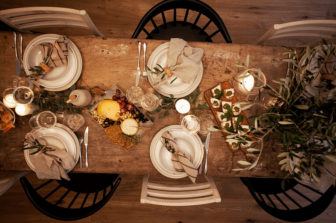 Festive table setting with candles and olive branches