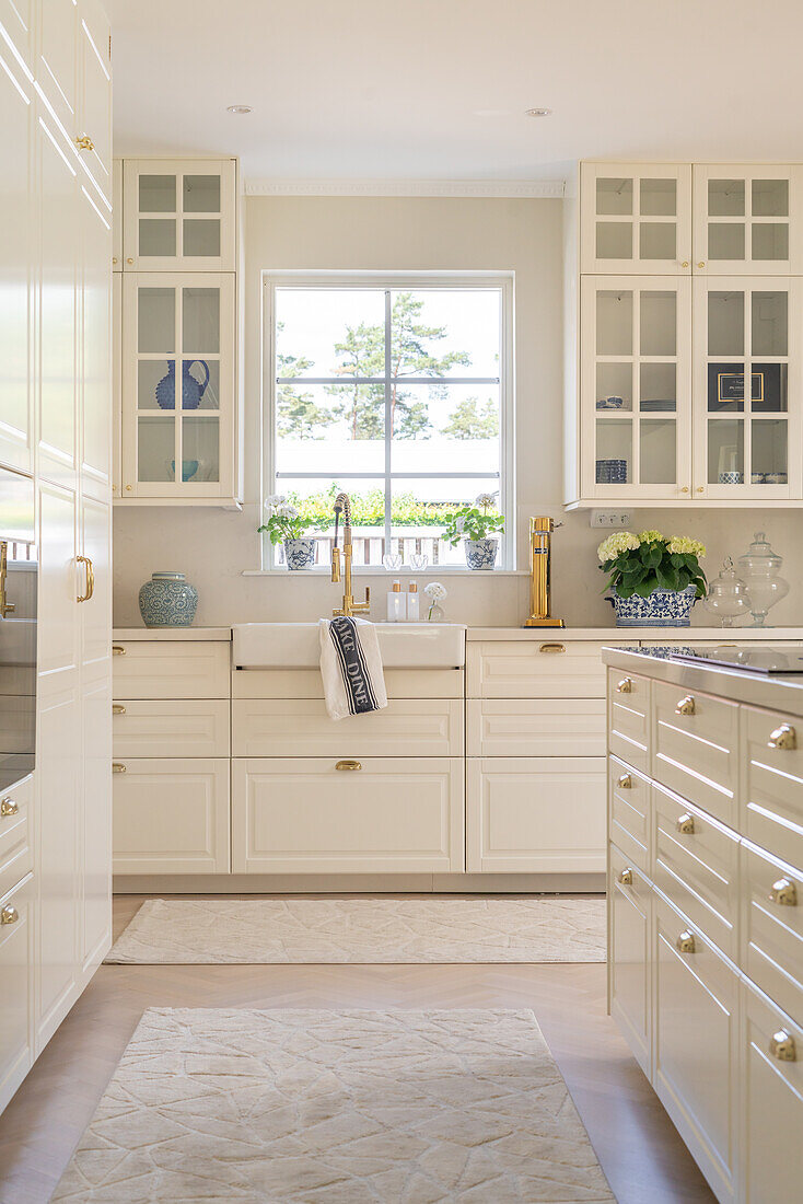 Bright kitchen with white cabinets and gold-colored hardware