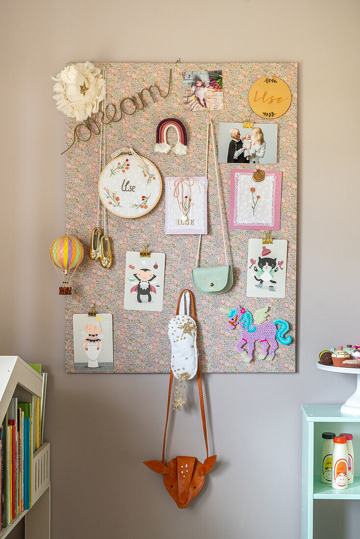 Creatively designed pinboard with decorative elements, cards and photos in the children's room