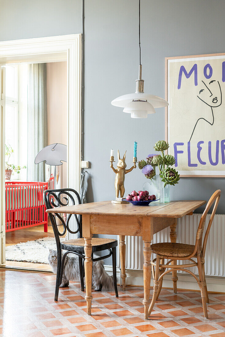 Dining area with wooden table, pendant light and large picture