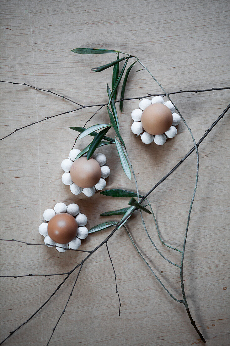 Easter decoration with eggs and twigs in the shape of flowers on a wooden background