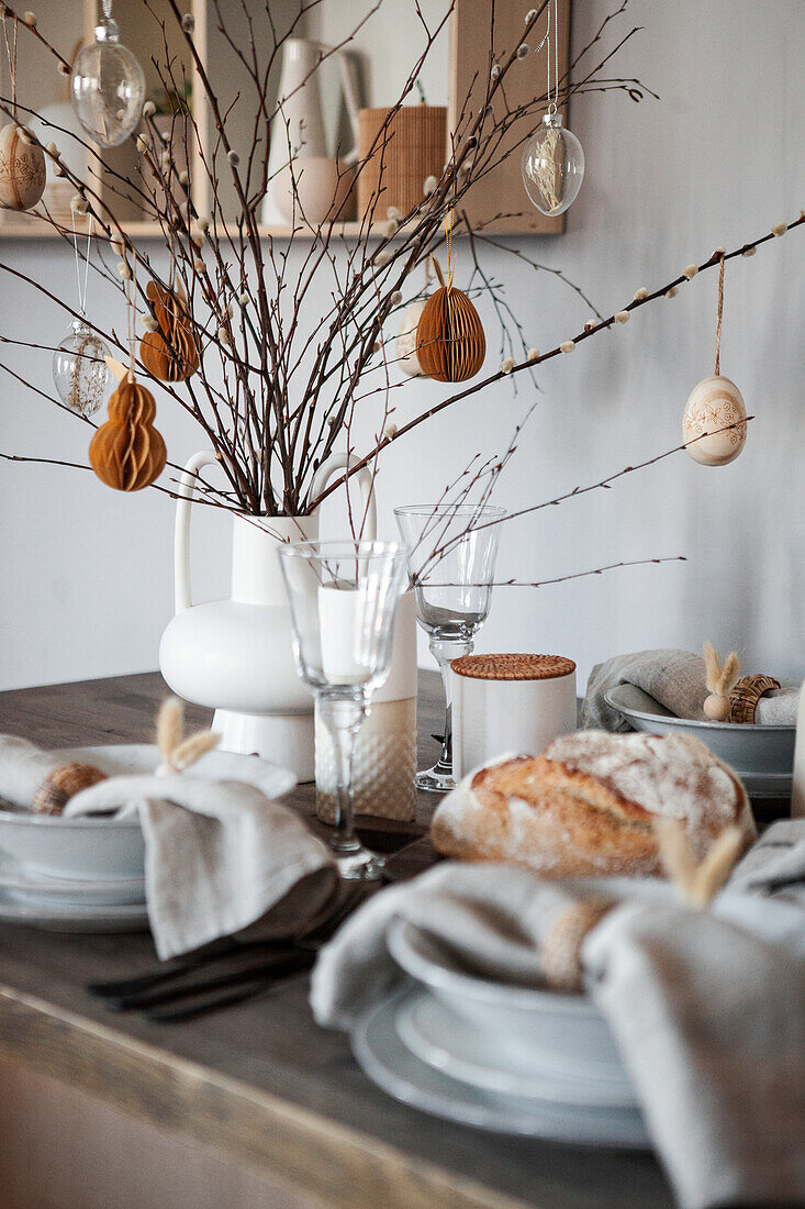 Spring table decoration with twigs and ornaments in natural colors