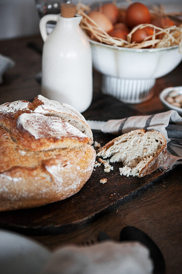 Frisch gebackenes Brot mit Kruste, Schale mit Eiern