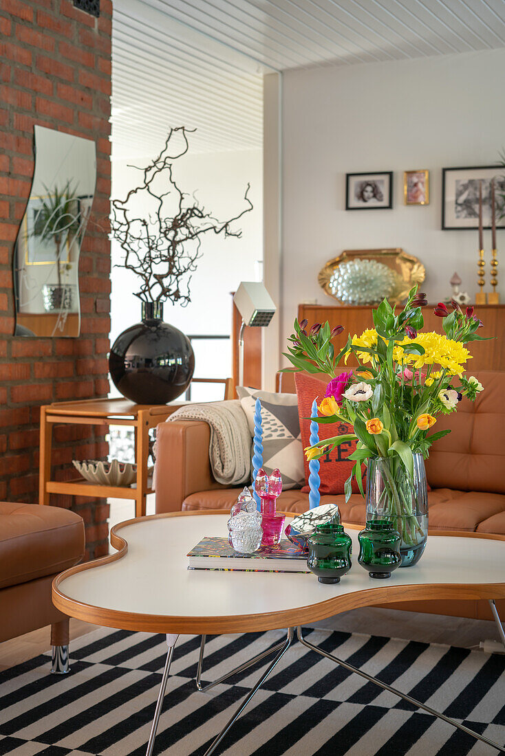 Living room with striped carpet, brick wall and colourful flower arrangement