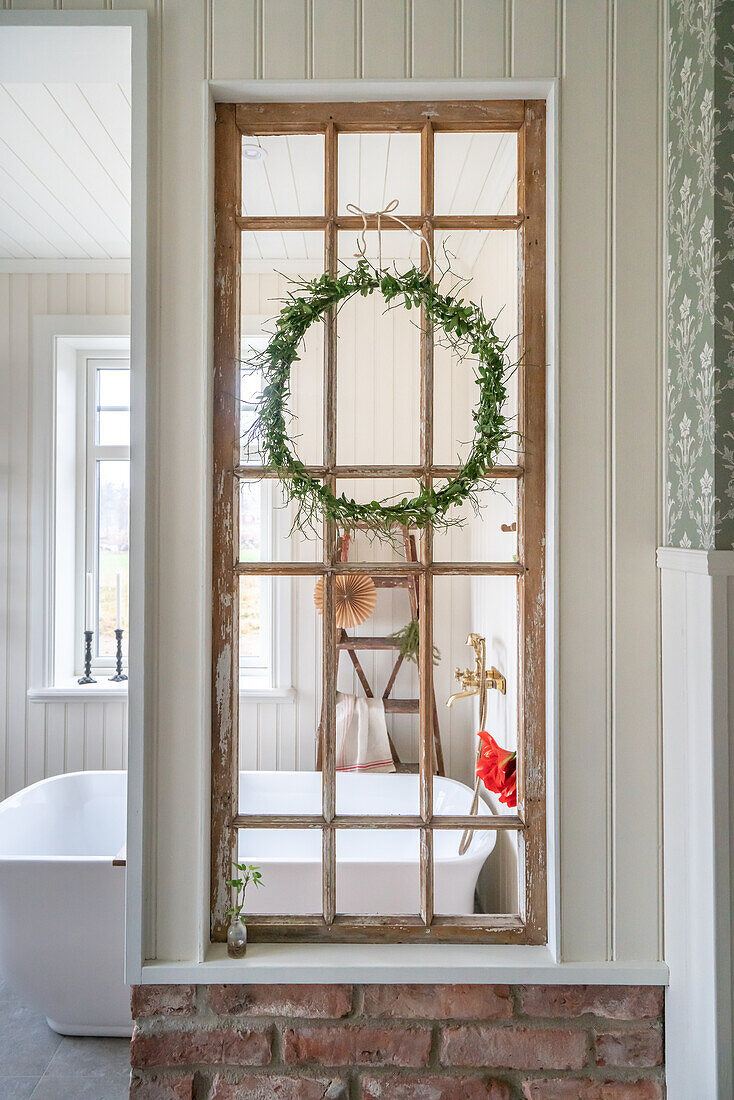 Old window as decorative element with wreath in bathroom