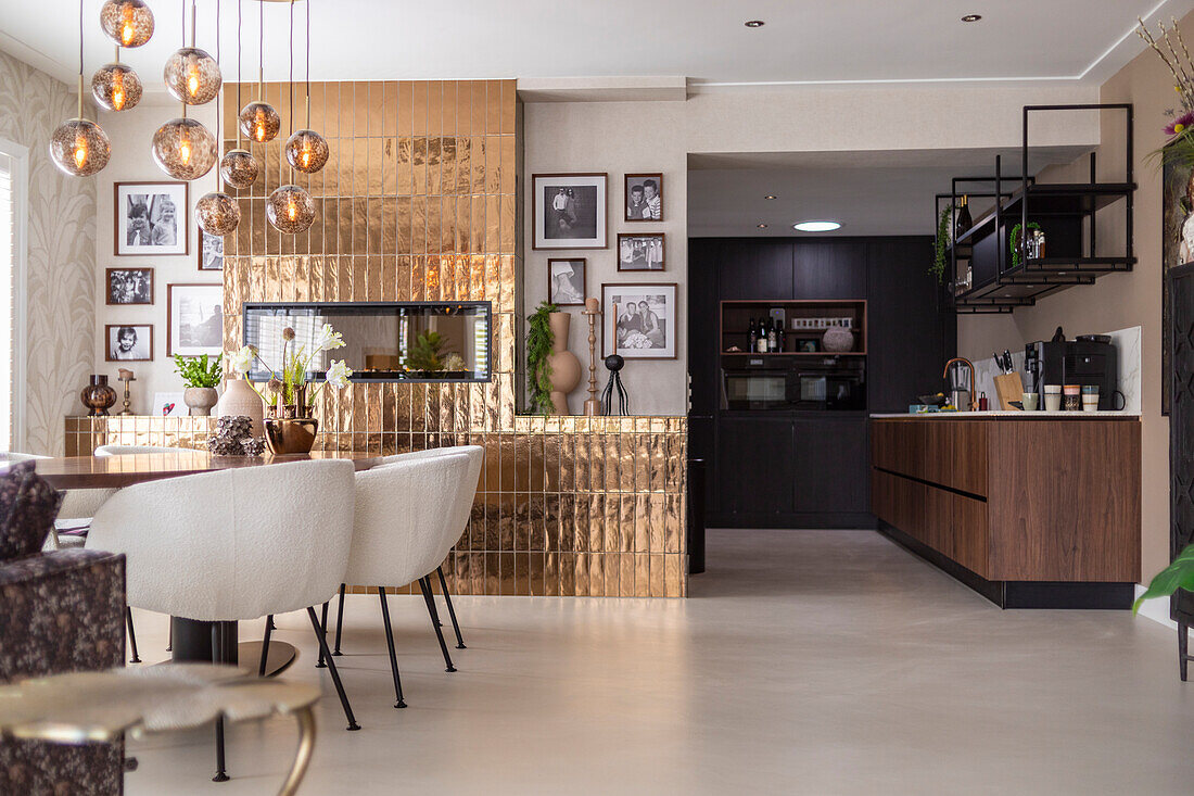 Modern kitchen with dining area, pendant light and gold-coloured wall tiles