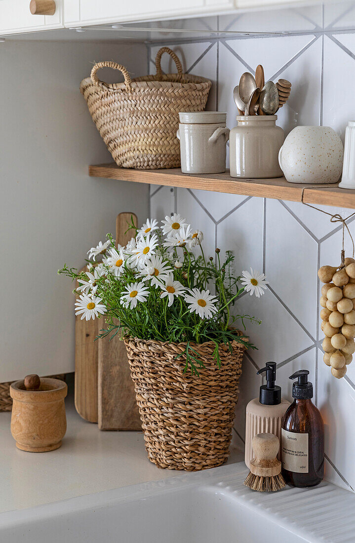 Margarites in a woven basket and kitchen utensils next to a sink