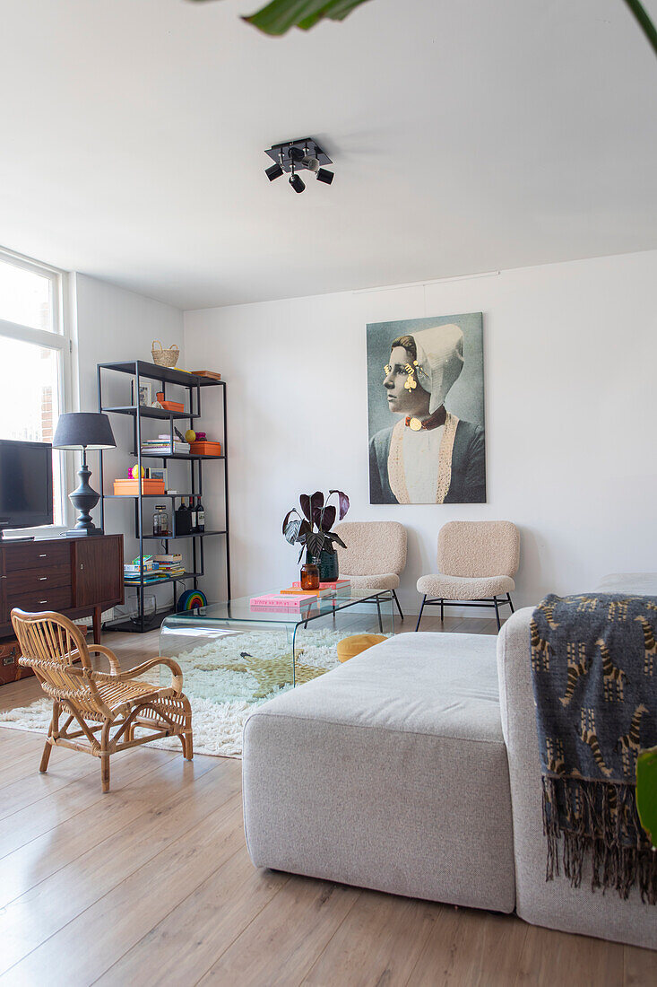 Bright living room with a mix of retro and modern furniture, large work of art on the wall