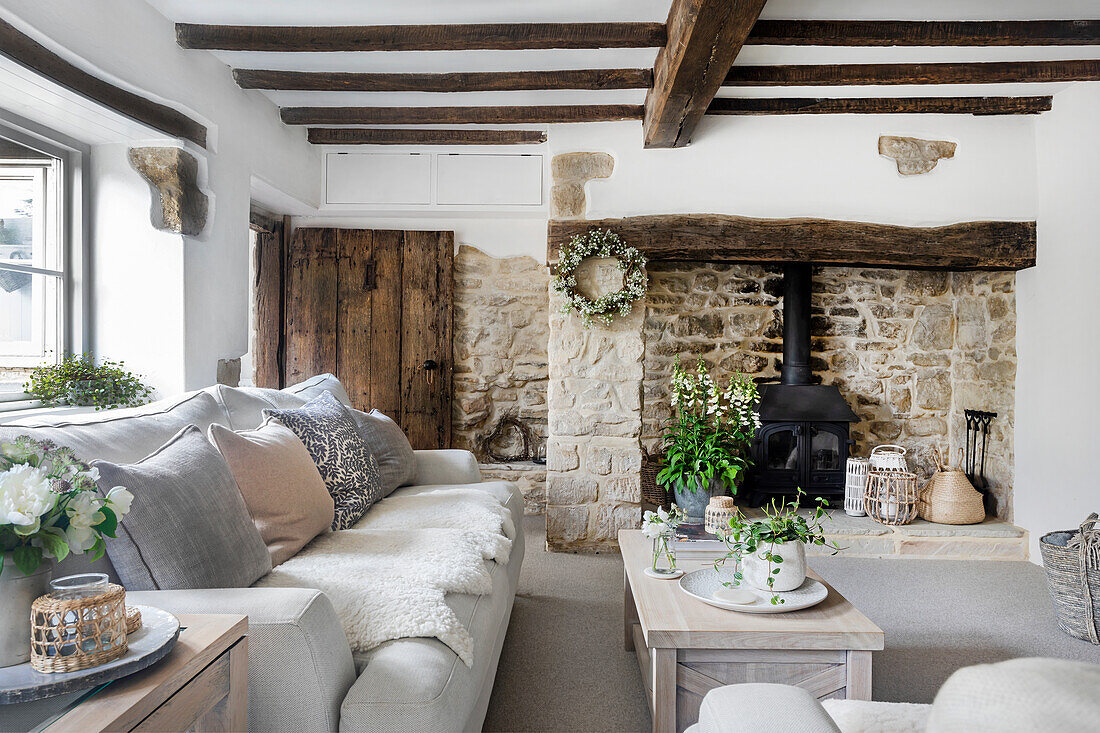 Rustic living room with natural stone wall and wooden beamed ceiling