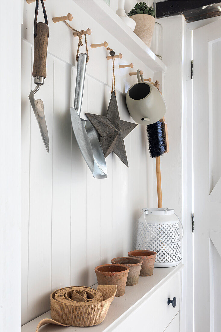 Gartengeräte and Garderobenhaken, Tontöpfe auf weißem Sideboard