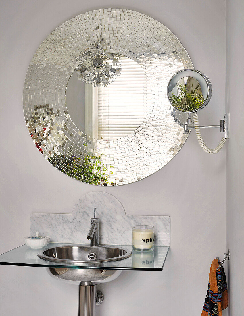 Round mosaic mirror above a modern sink in the bathroom