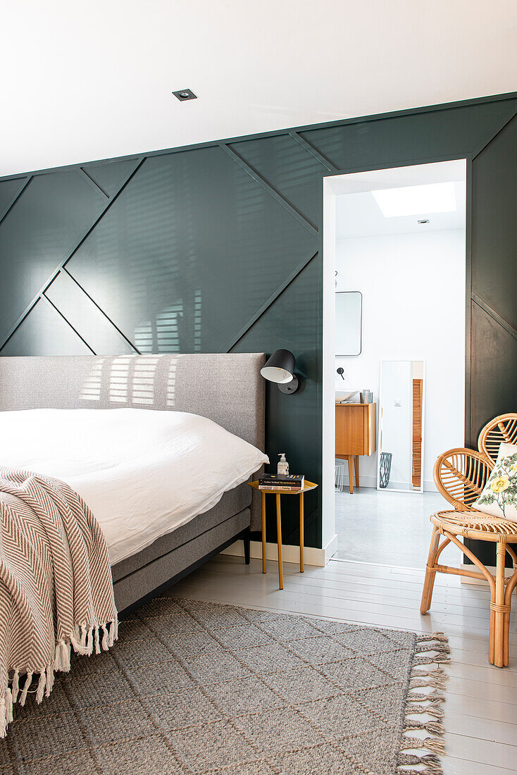 Modern bedroom with geometric wall design and en suite bathroom