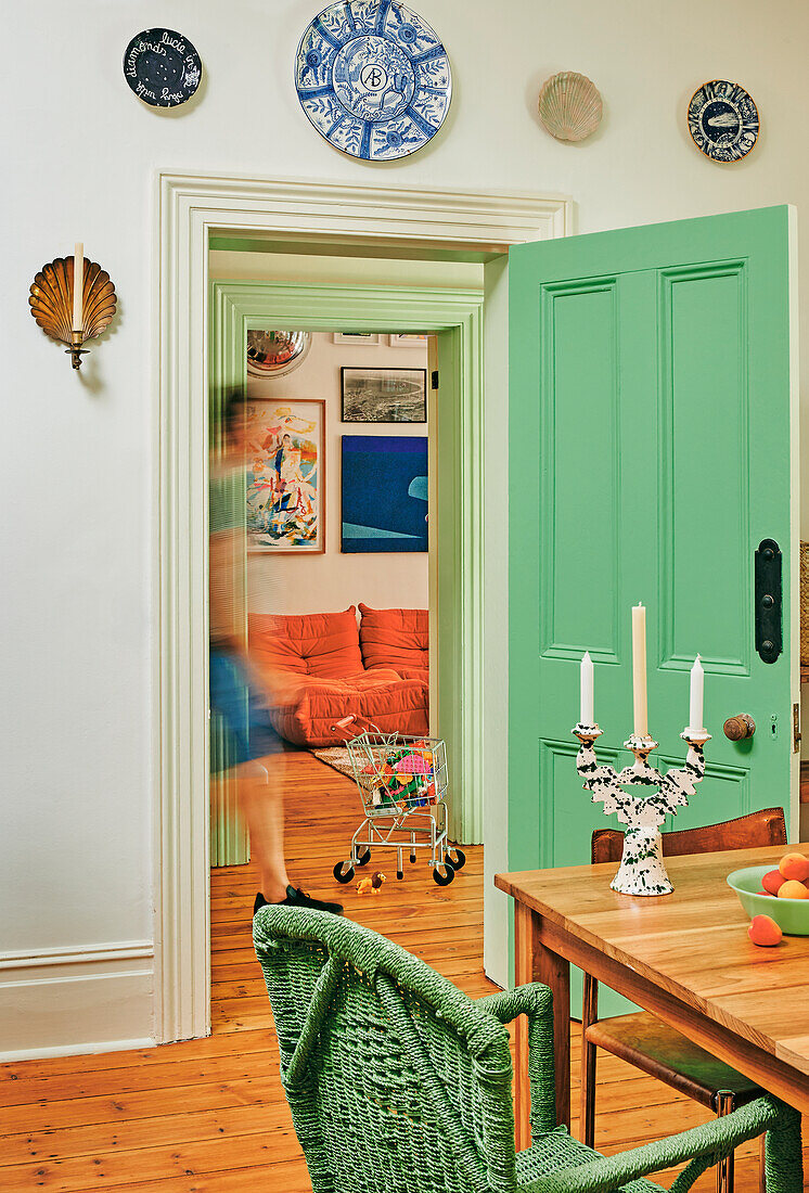 Esszimmer mit grüner Tür und Wandtellern als Dekoration