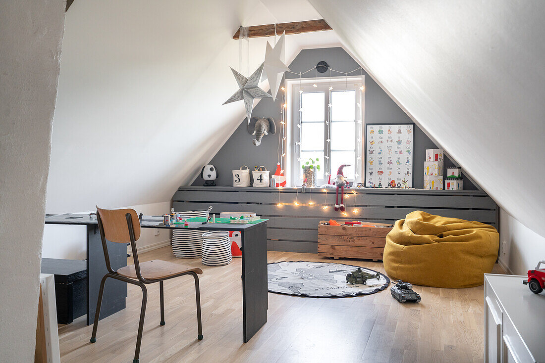 Attic as children's room with table and cosy seating area