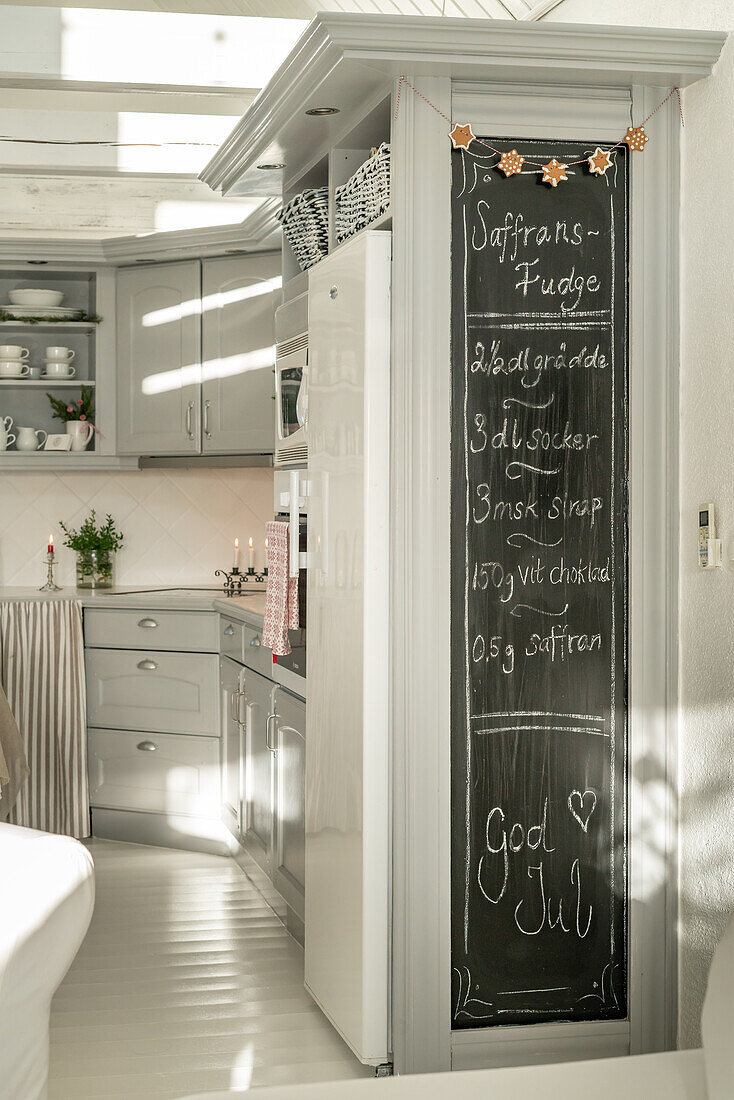 Scandinavian-style kitchen with blackboard for recipes and Christmas decorations