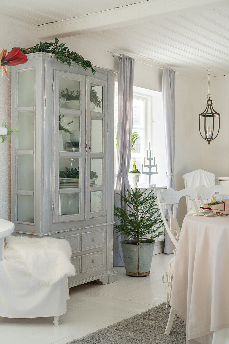 Light grey painted display cabinet in the brightly decorated dining room