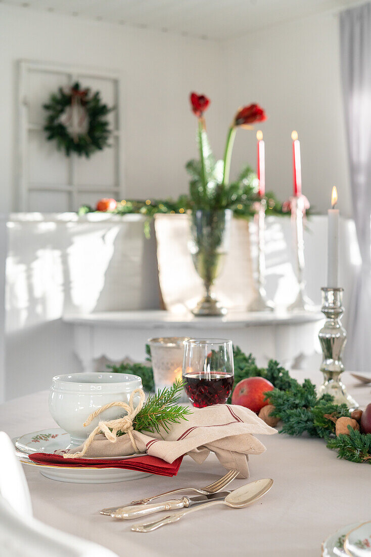 Festlich gedeckter Esstisch mit roten Amaryllis (Hippeastrum) und Weihnachtsdekoration