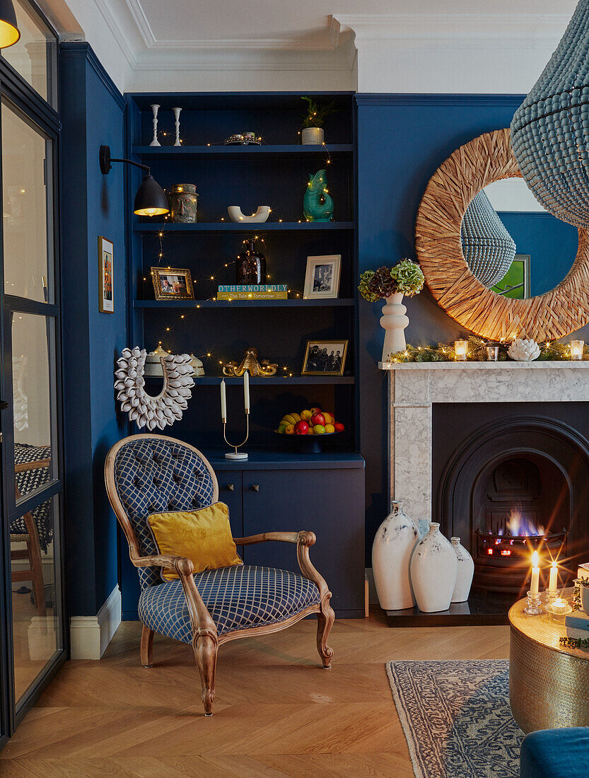 Offene Regale neben Kamin im Wohnzimmer mit blauen Wänden und Weihnachtsdekoration