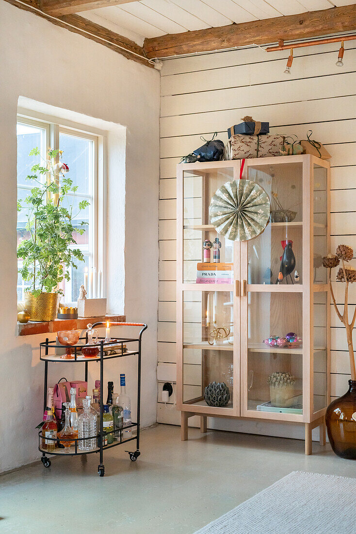 Bright corner with bar trolley and display cabinet in the living room