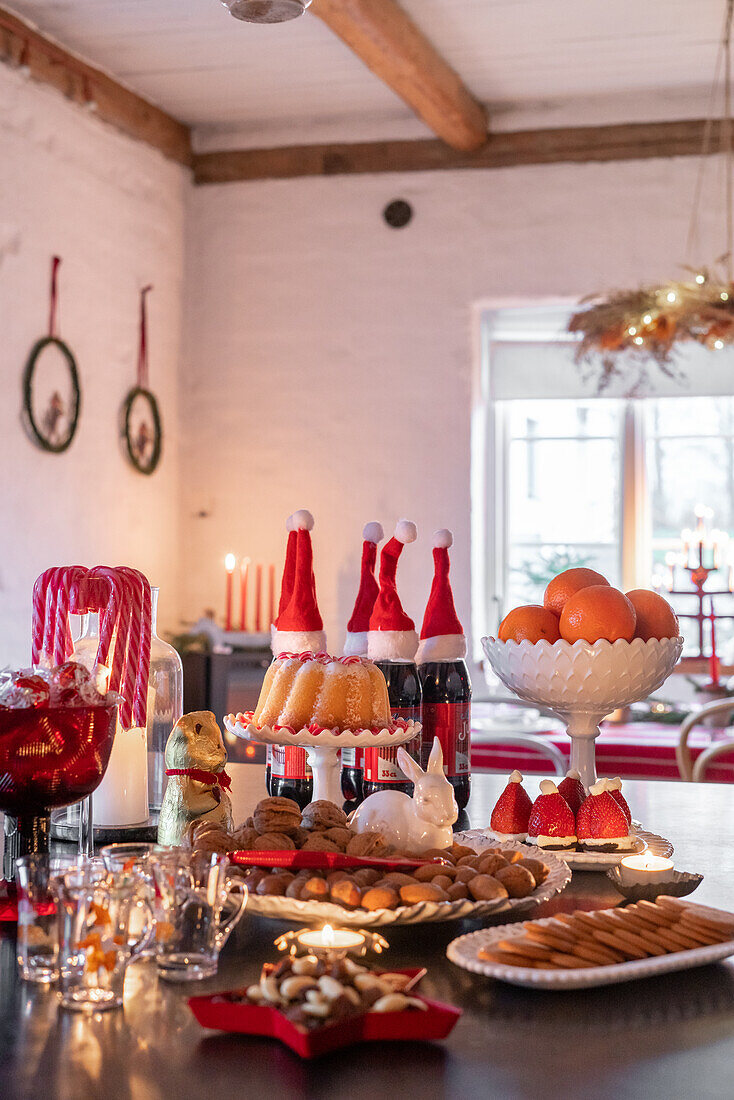 Weihnachtlich gedeckter Tisch mit Punsch, Gebäck und Dekofiguren