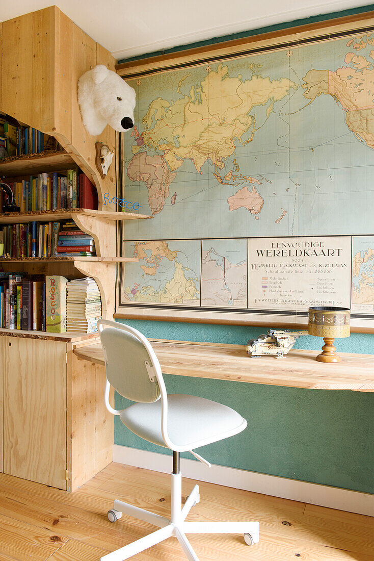 Customized shelves and desk in light wood, world map on the wall in the children's room
