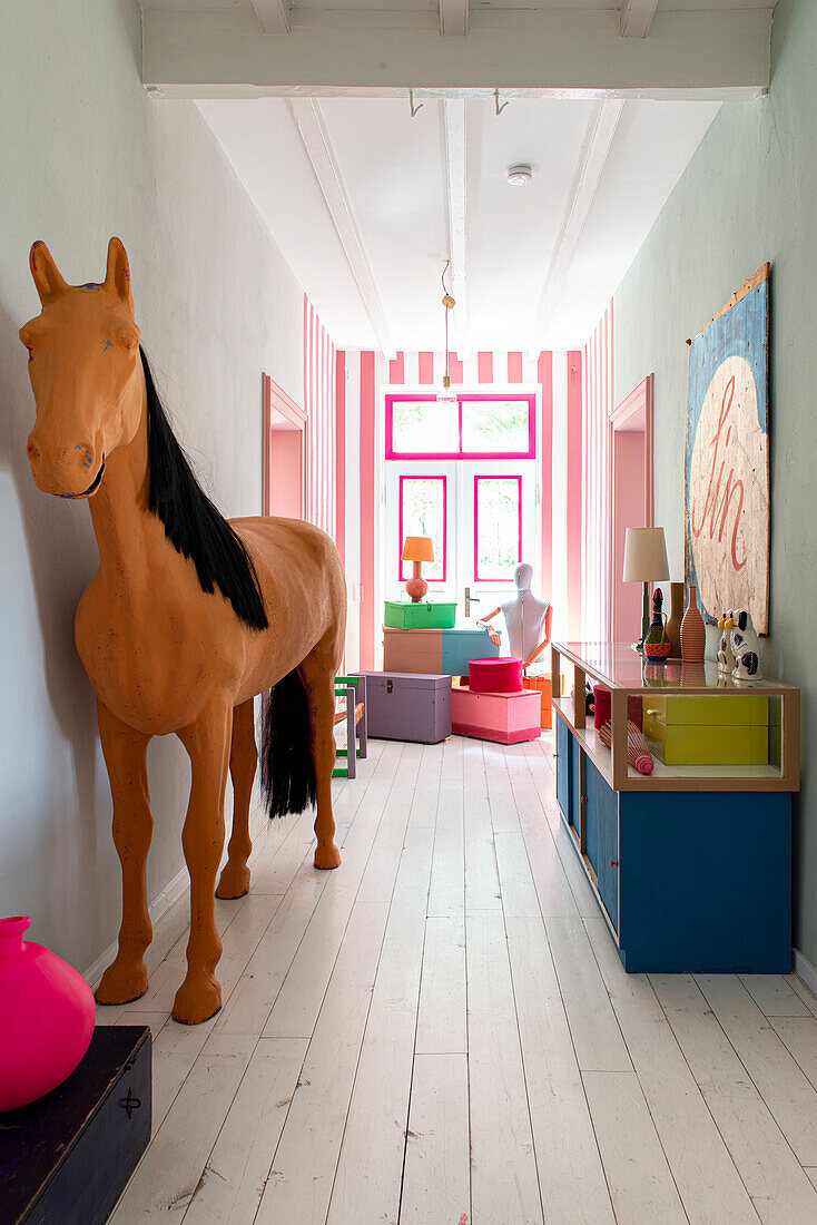 Hallway with decorative horse, colorful accent furniture and artwork