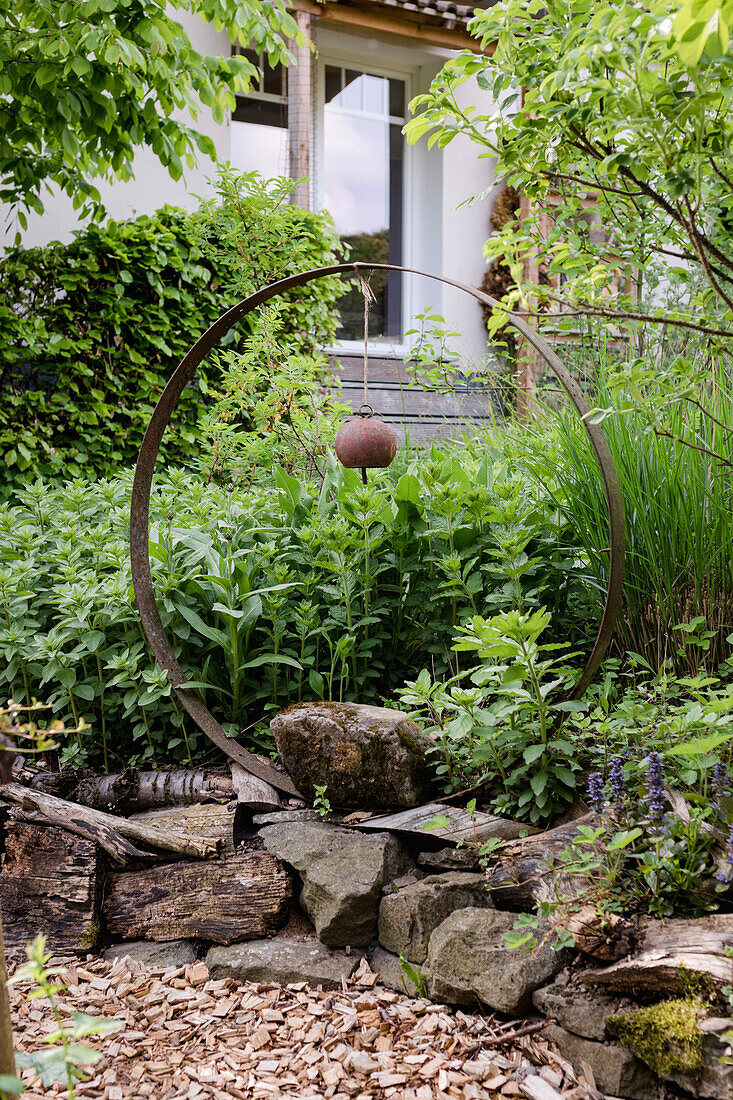 Creative garden design with rust sculpture and natural stone wall