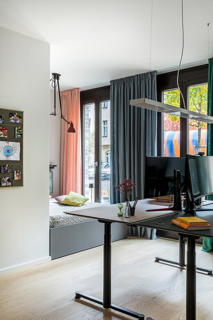 Workplace with height-adjustable desk in front of window front