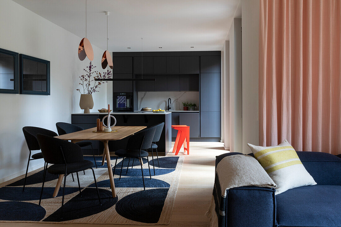 Modern dining room with dark kitchen in the background