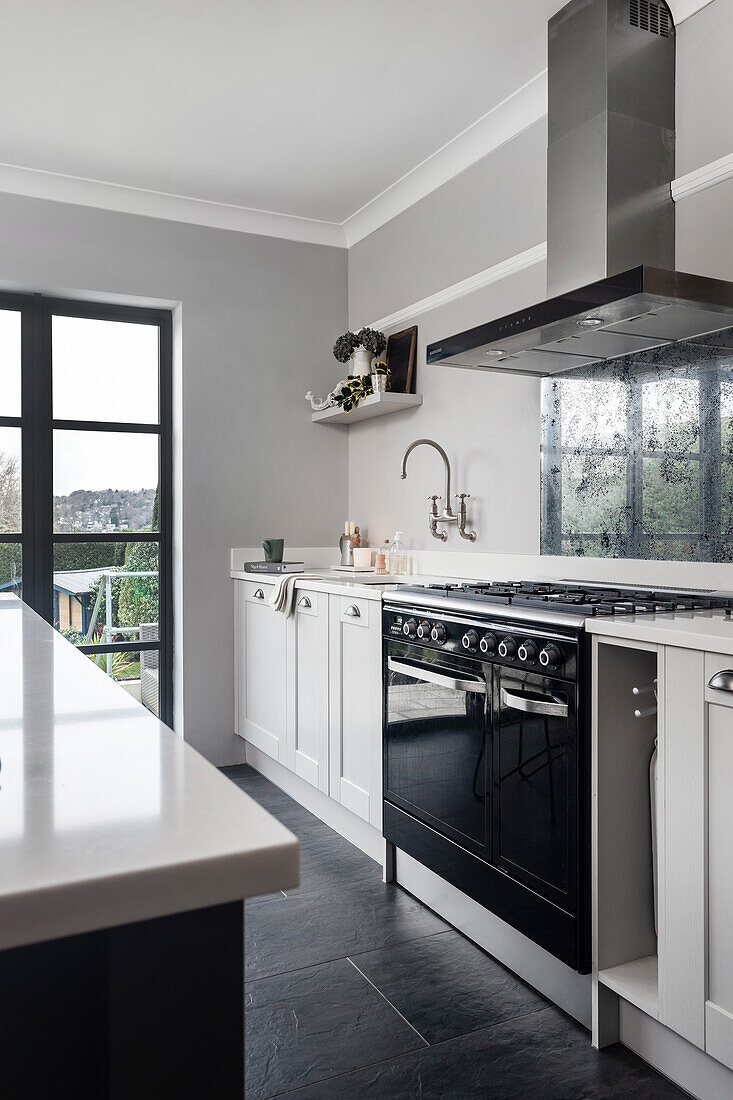 Moderne Küchenzeile in Weiß mit dunklen Bodenfliesen und grauen Wänden