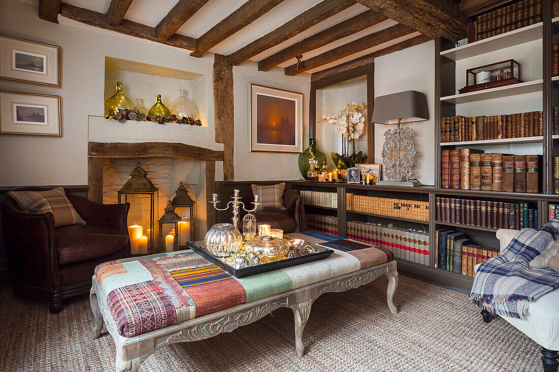 Rustic living room with fireplace, wooden beams and bookshelves