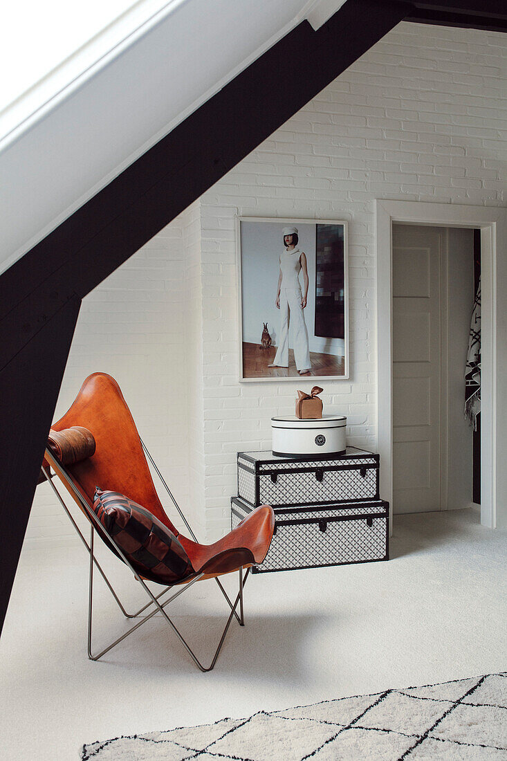 Modern attic flat with designer armchair and white brick walls