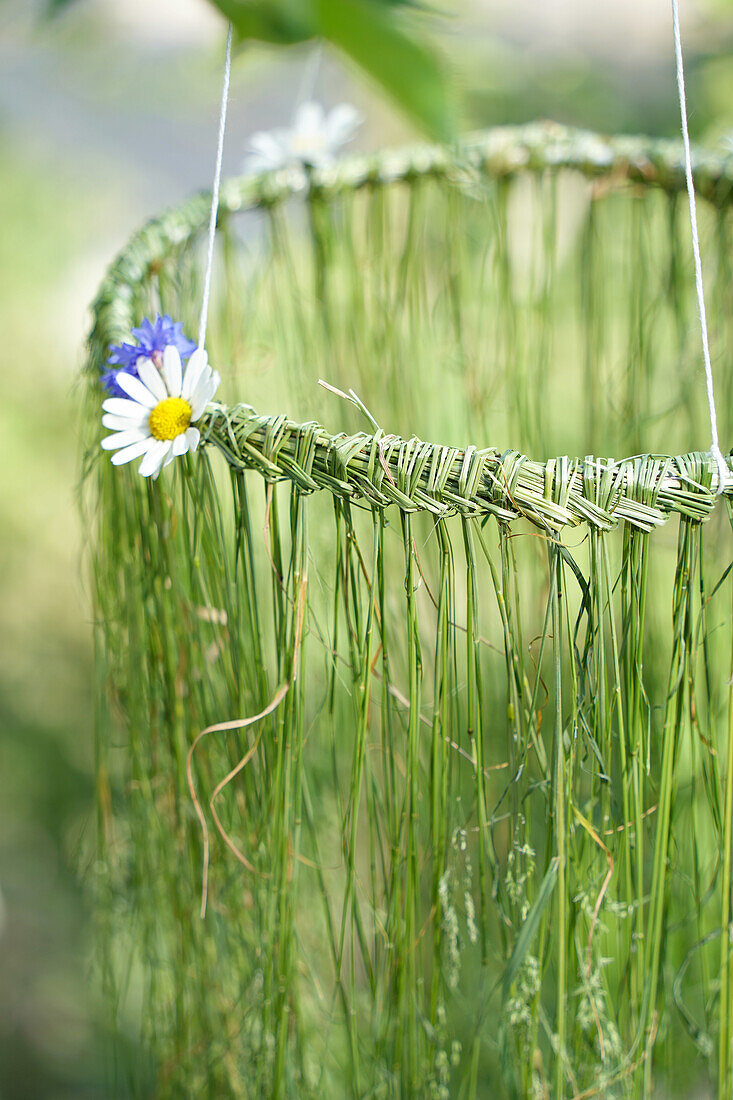 DIY-Hängedekoration aus geflochtenen Gräsern und Blumen