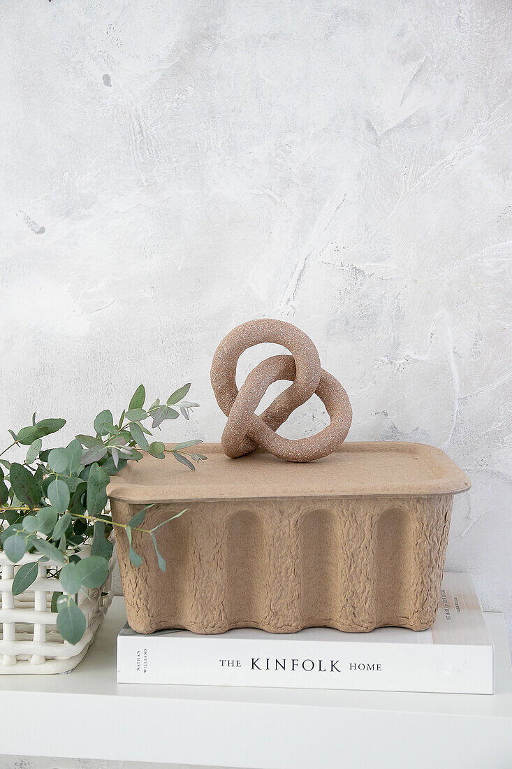 Decorative sculpture and eucalyptus on shelf