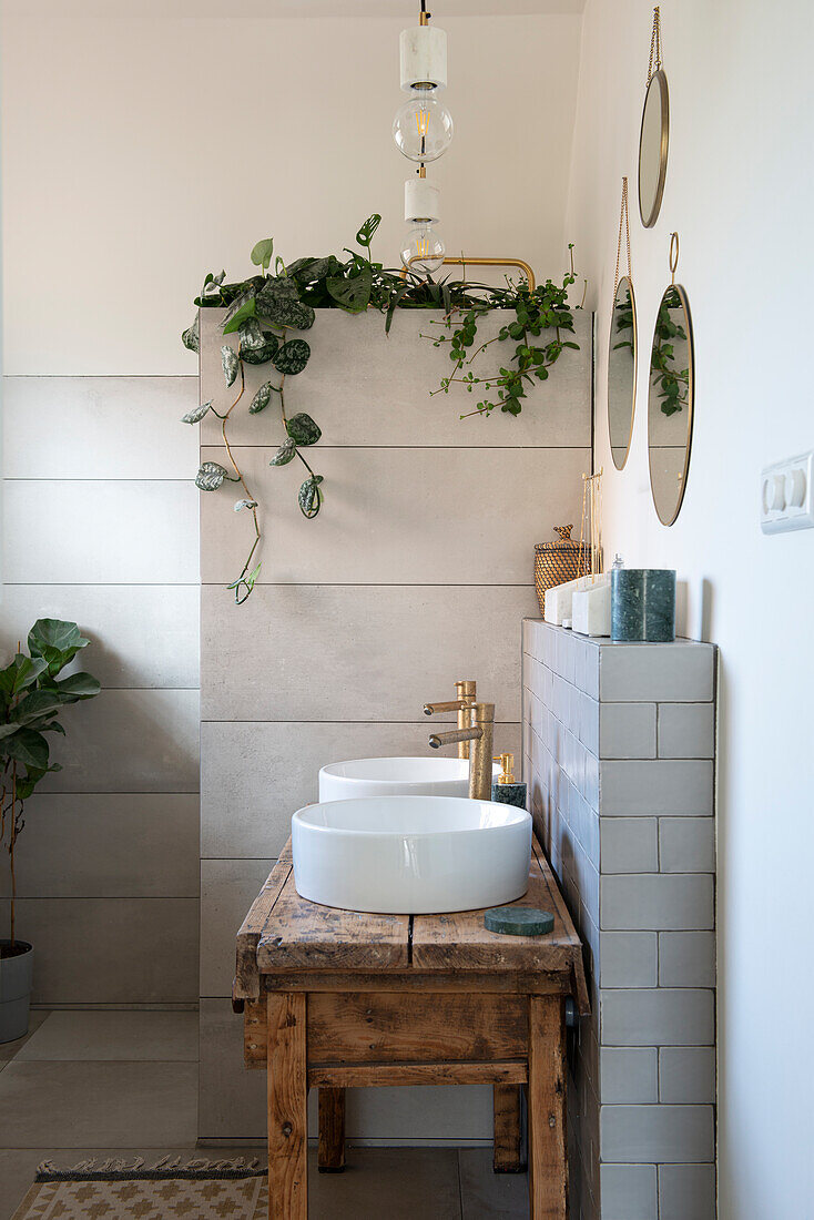 Modernes Badezimmer mit Pflanzen und Vintage-Holztisch als Waschtischkonsole