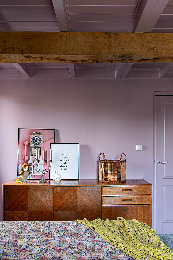 Retro Sideboard mit Dekoration im Schlafzimmer mit sichtbaren Holzbalken