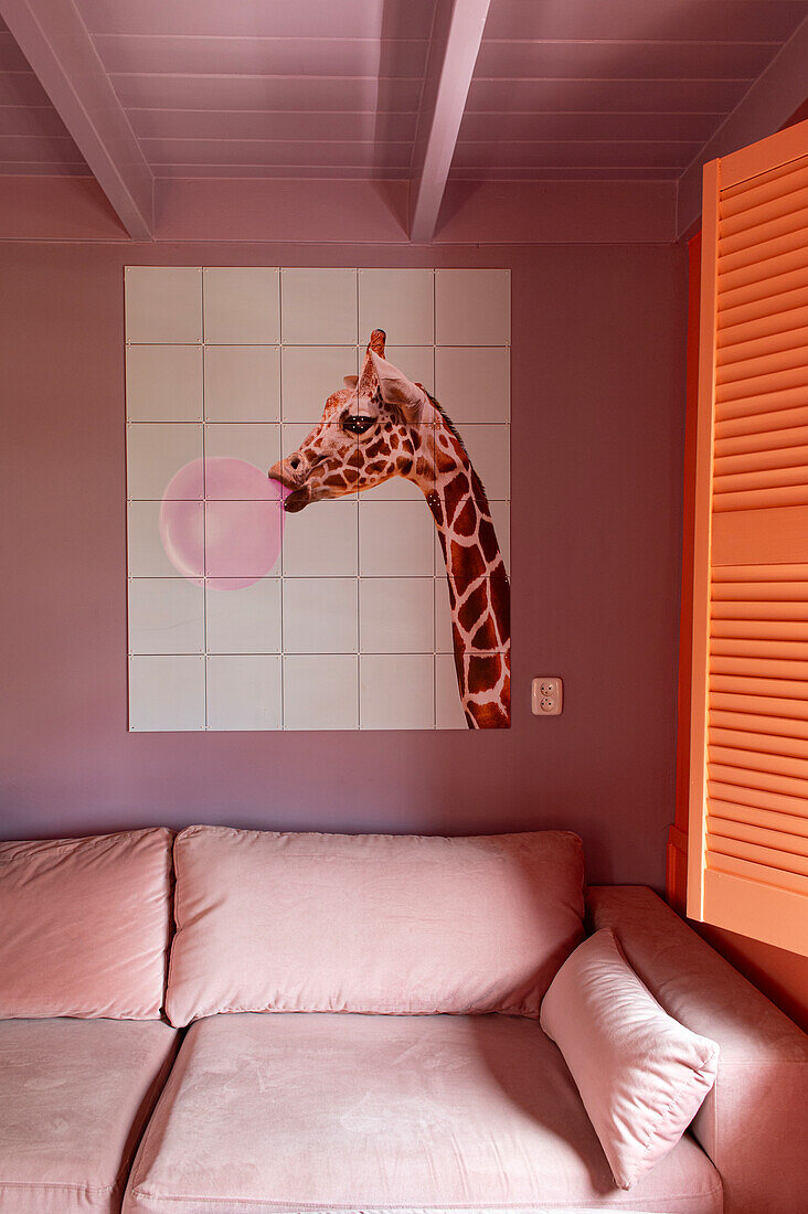 Wandgestaltung mit Giraffenbild und rosa Sofa