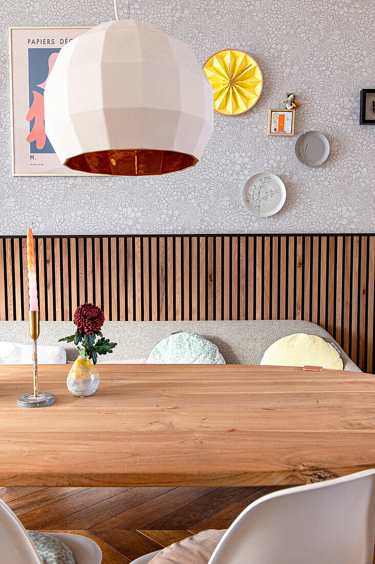 Dining room in Scandinavian design with wooden table, wall decoration and pendant light