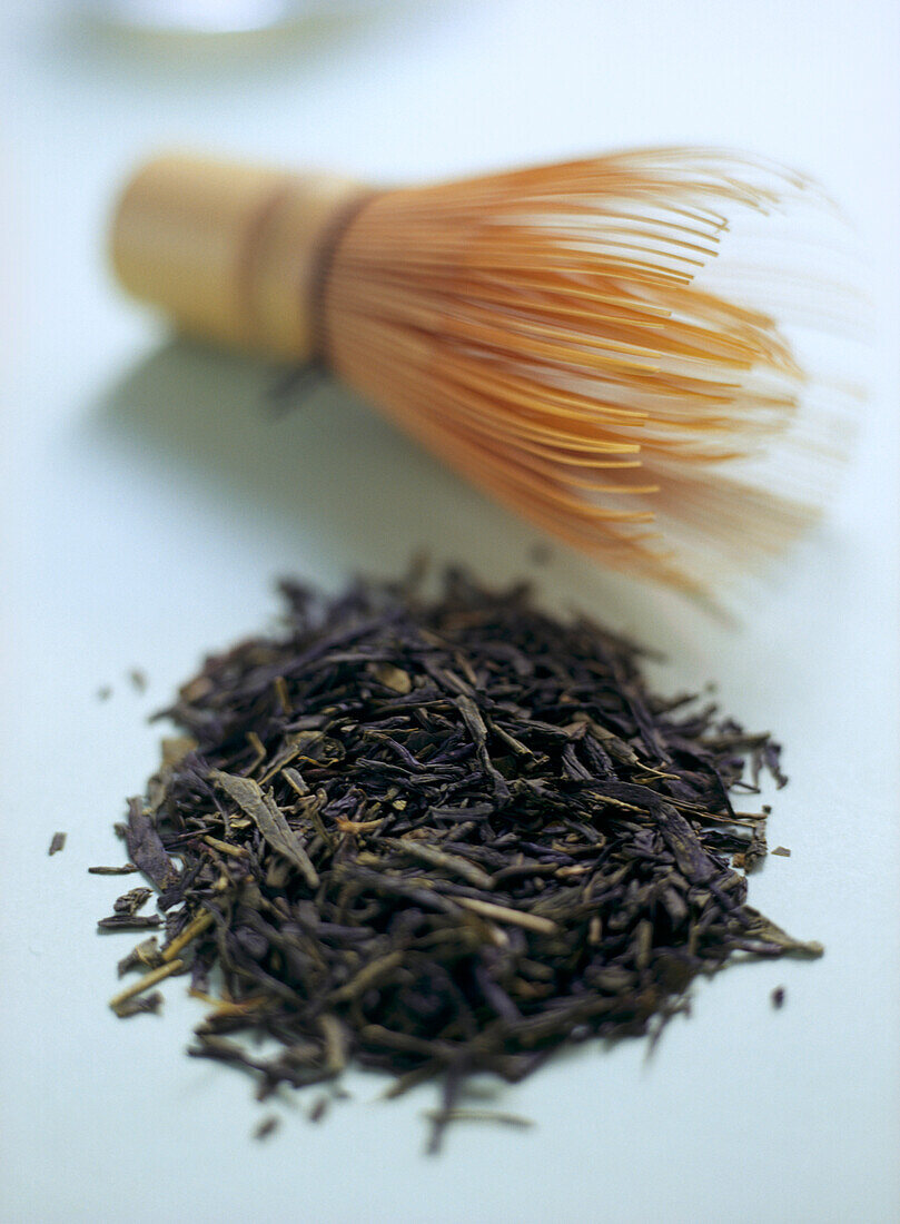 Japanese green tea leaves with traditional bamboo tea whisk