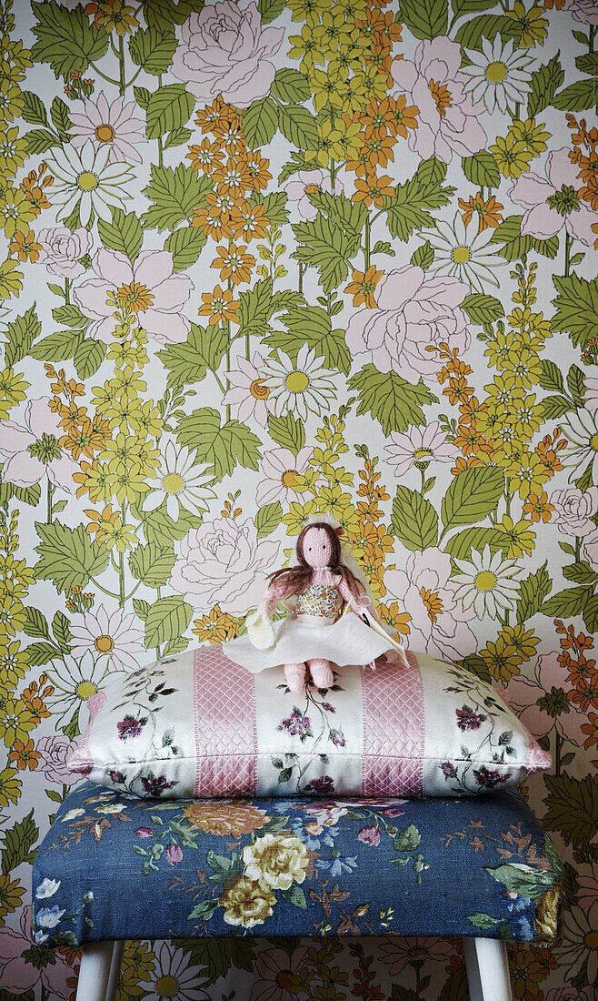 Rag doll on floral patterned cushions with retro wallpaper in Brighton home East Sussex, England, UK