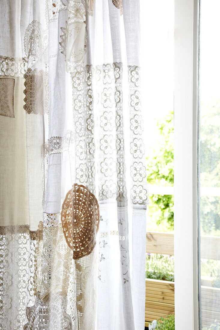 White lace curtains hang in sliding doorway of Brighton home East Sussex, England, UK
