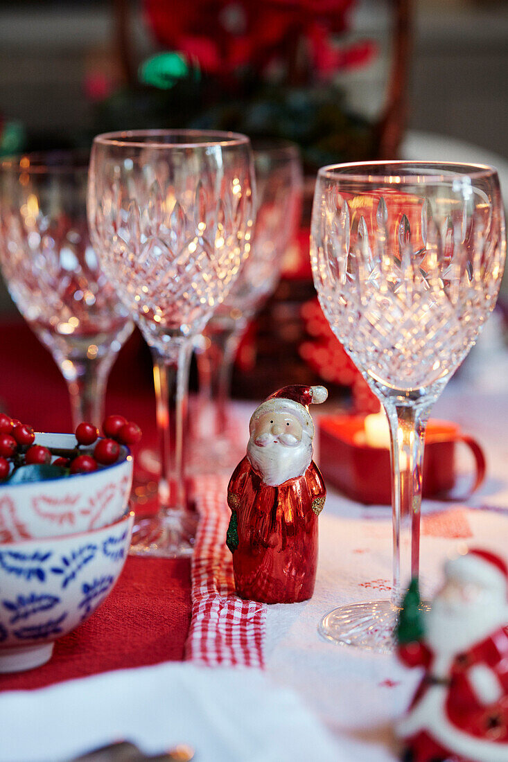 Weihnachtsmann aus geschliffenem Glas und Schokolade auf dem Esstisch zu Weihnachten