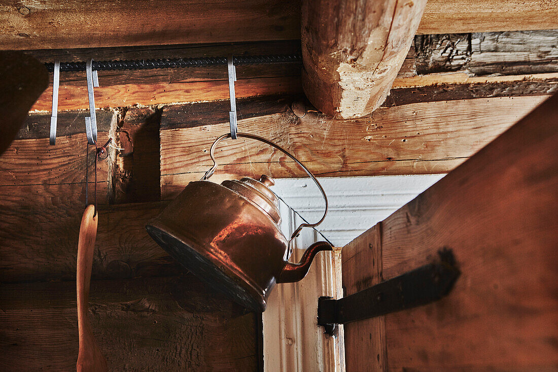 Kupferkessel an einem Fleischhaken hängend in einer Holzhütte in den Bergen von Sirdal, Norwegen