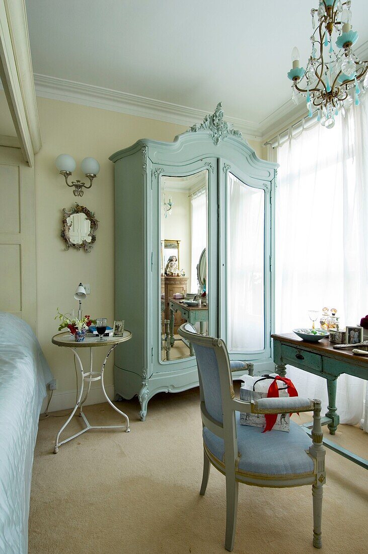 Schlafzimmer mit Kleiderschrank, Spiegel, Sessel und Nachttisch