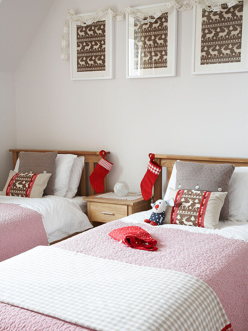 Zwillingsbetten mit Weihnachtsstrümpfen und dazu passenden Rentier-Kunstwerken und Kissen in einem polnischen Haus