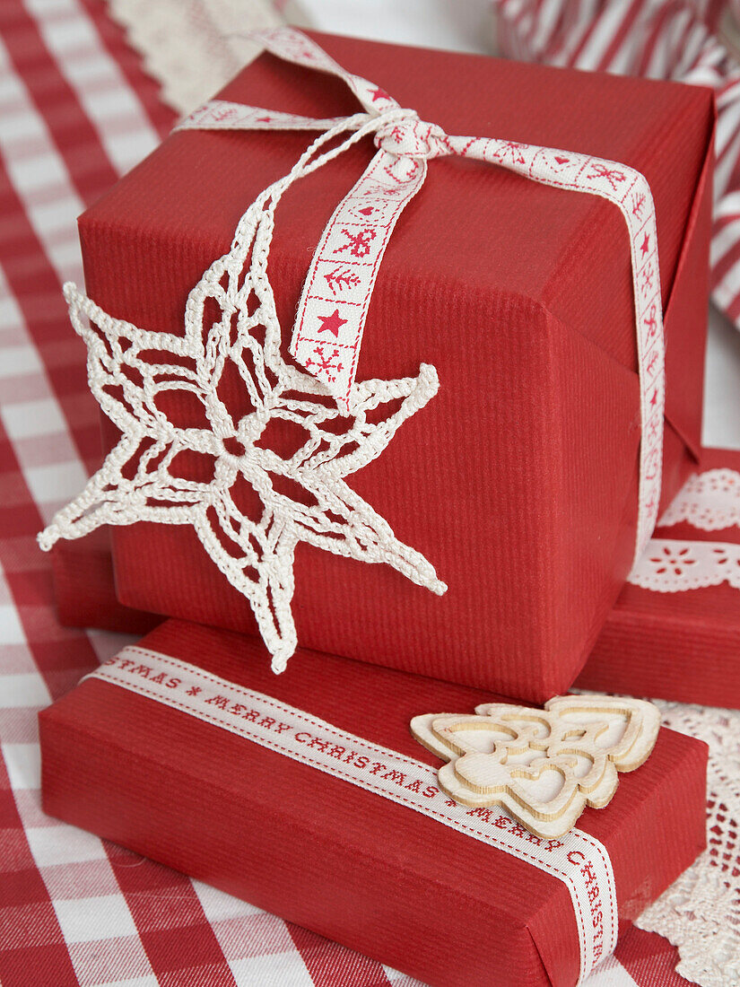 Handgemachte Schneeflocken auf rot verpackten Weihnachtsgeschenken in einem polnischen Haus