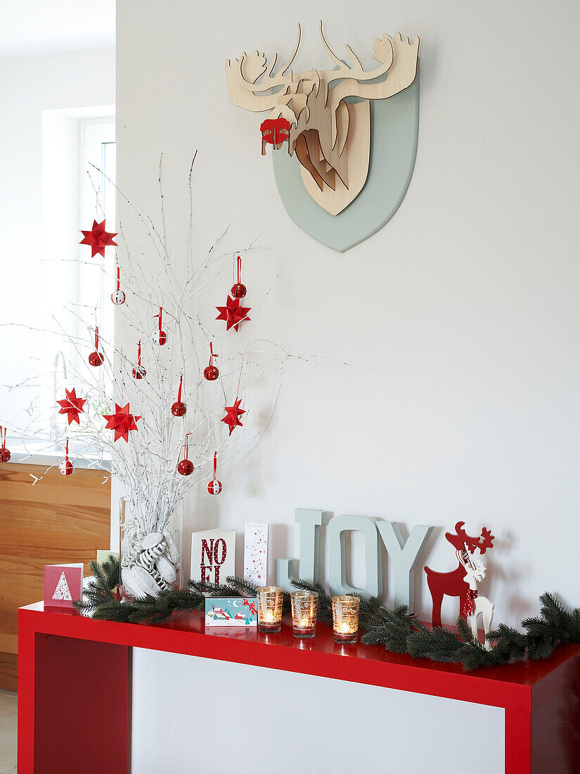 Zeitgenössische Weihnachtsdekoration auf einem roten Konsolentisch in einem polnischen Familienhaus