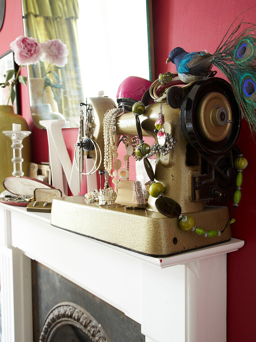 Vintage jewellery on sewing machine on fireplace in Winchester home, Hampshire, UK