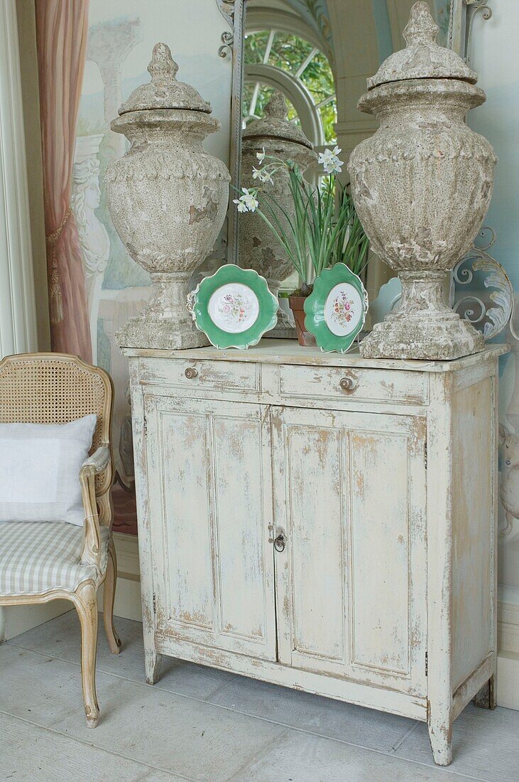 Altmodischer Schrank mit Vasen und dekorativen Tellern